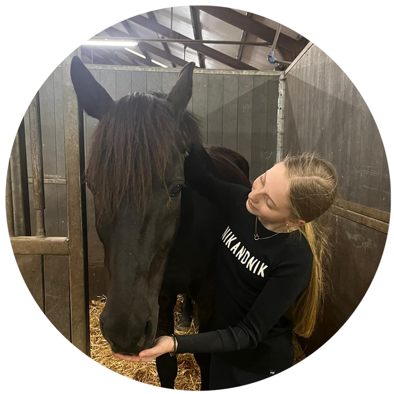 Een paardenmeisje knuffelt haar paard in stal