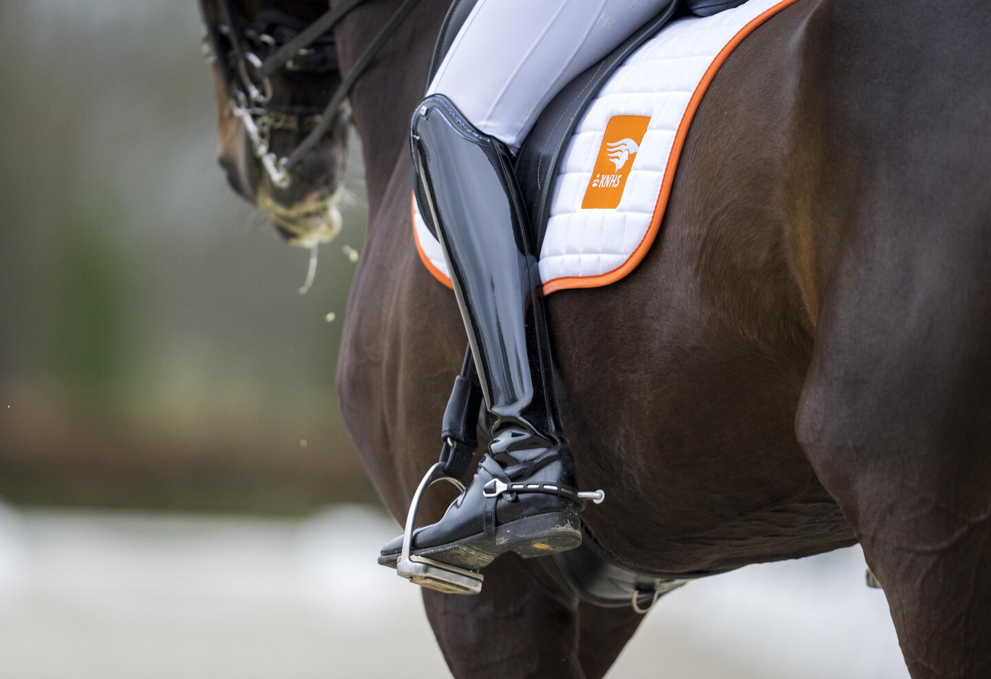 detailfoto van de benen van een ruiter die op een paard zit
