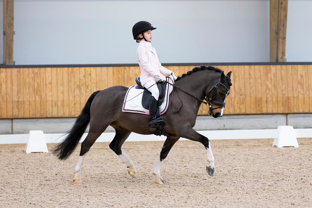dinja van liere juicht terwijl ze op hermes zit, na het winnen van de nederlandse titel
