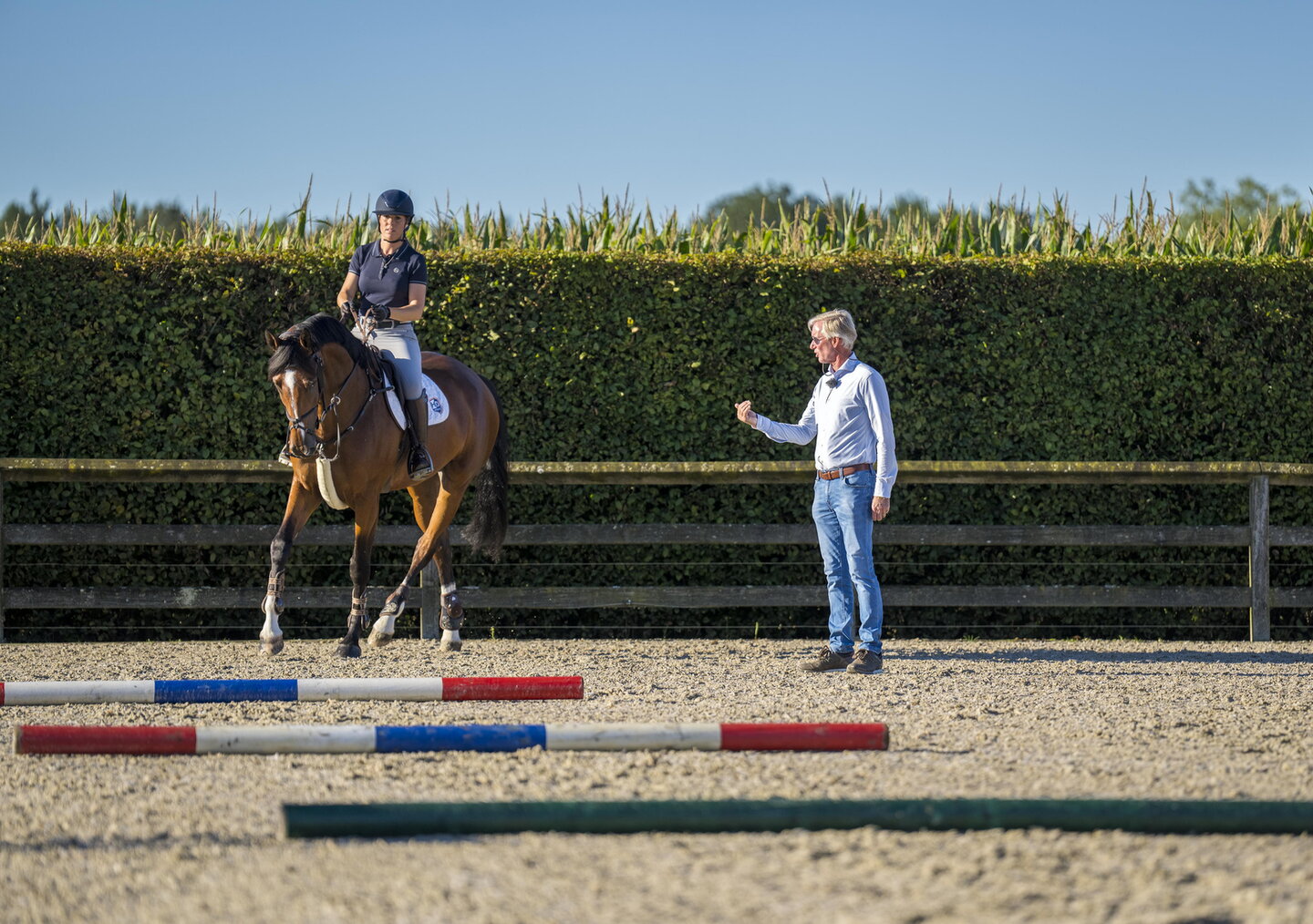 Instructeur Jos Lansink geeft les aan een combinatie over springbalkjes