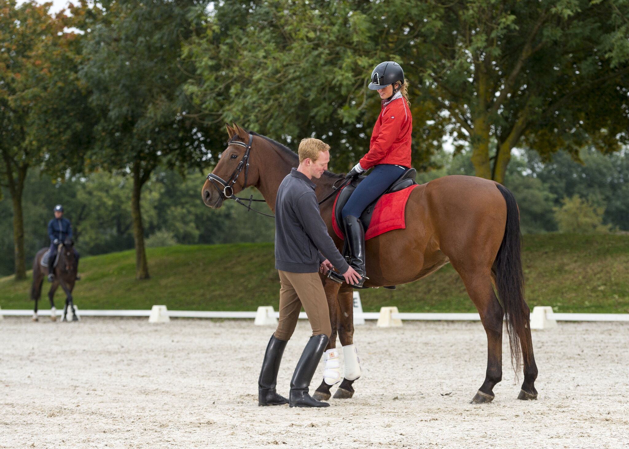 nathalie vink houdt een van haar therapiepaarden vast en kijkt in de camera
