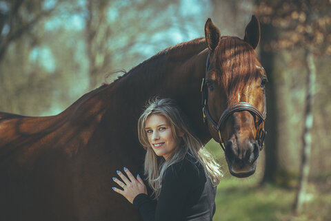 janneke boonzaaijer zit met een jack russel hondje op schoot in de zadelkamer