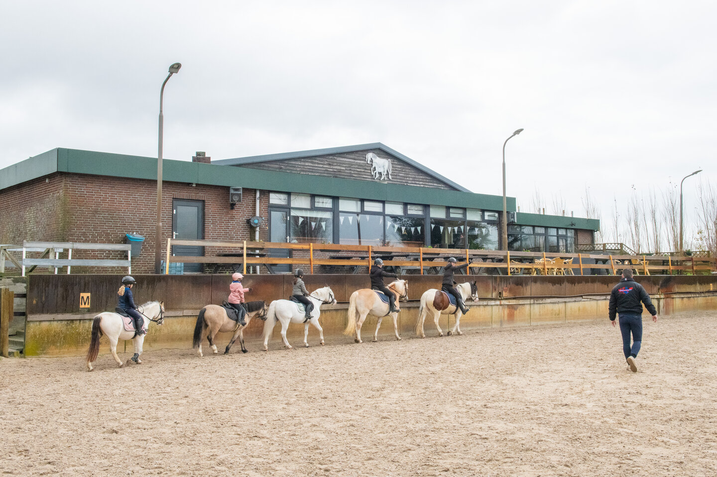 Instructeur Jos Lansink geeft les aan een combinatie over springbalkjes