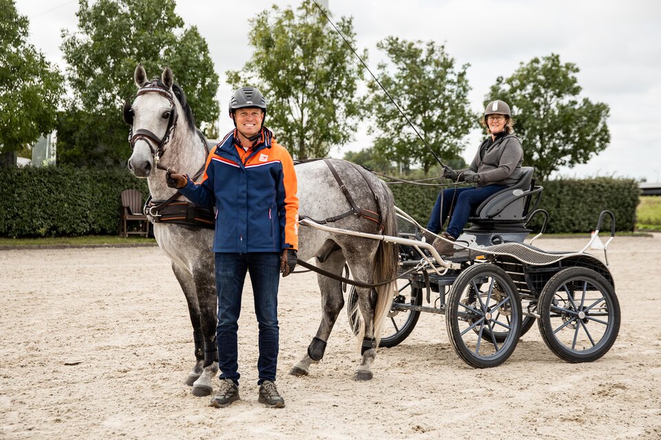 bram chardon poseert naast het paard terwijl tanja liesker op de wagen zit