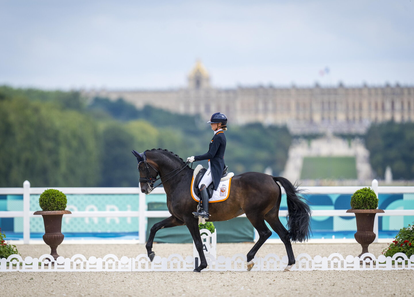 dinja van liere tijdens een olympische wedstrijd met hermès n.o.p. met het paleis van versailles op de achtergrond