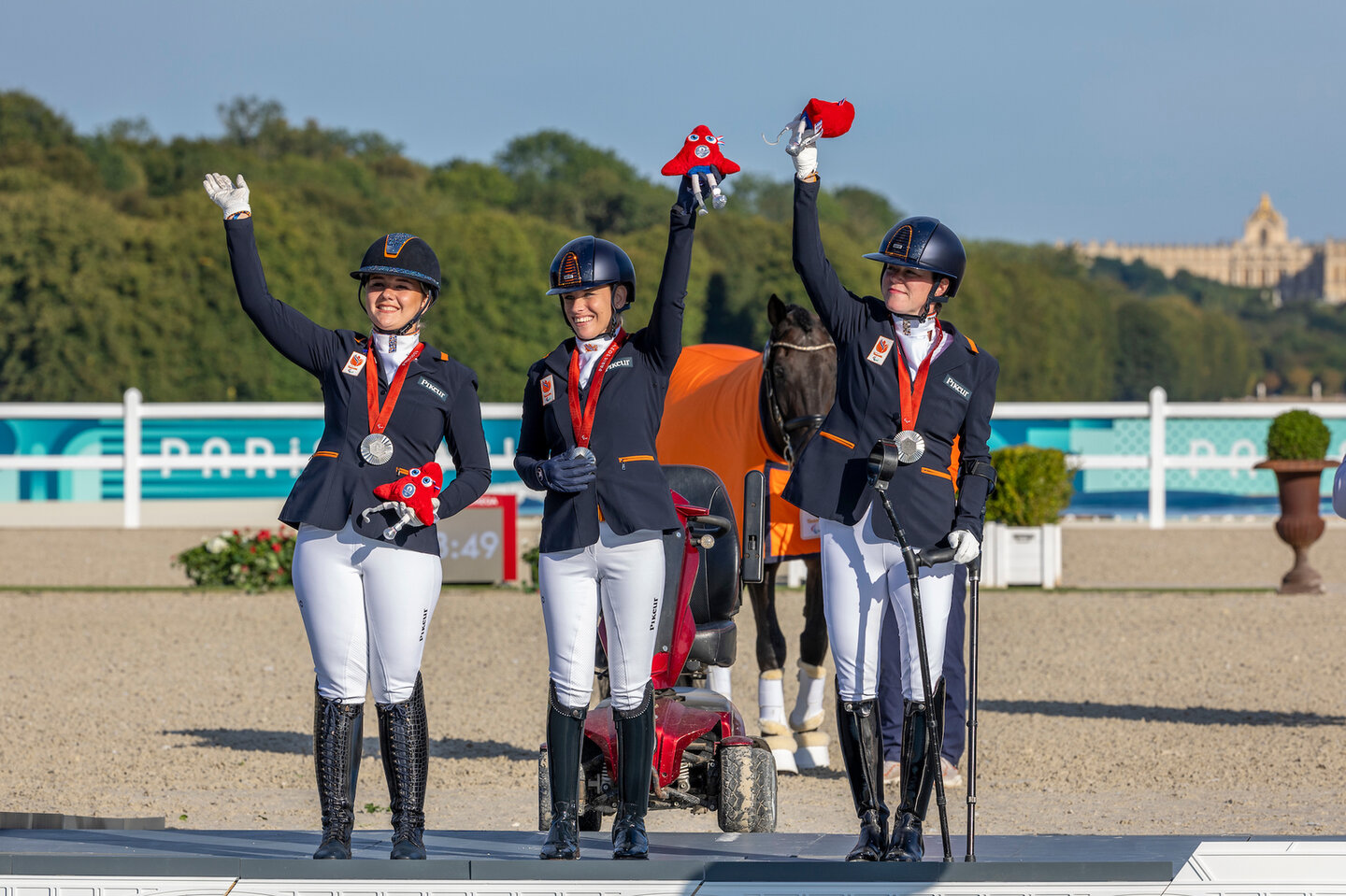 demi haerkens, rixt van der horst en sanne voets zwaaien op het podium na het behalen van teamzilver