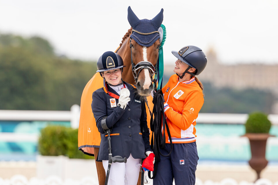 sanne voets showt haar zilveren medaille terwijl ze naast demantur rs2 n.o.p. en haar groom staat
