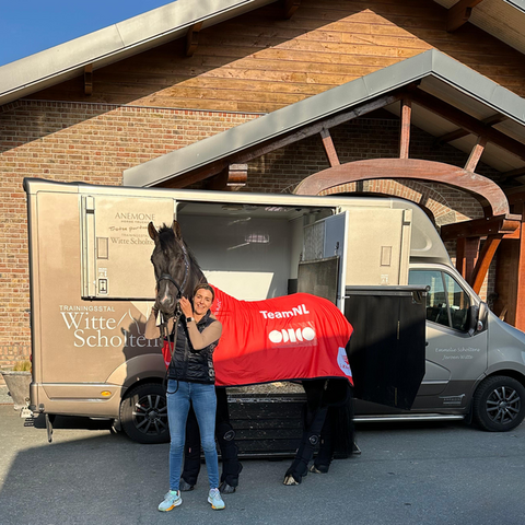emmelie scholtens poseert met indian rock voor de vrachtwagen van anemone horse trucks