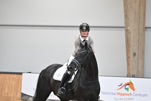 dinja van liere juicht terwijl ze op hermes zit, na het winnen van de nederlandse titel