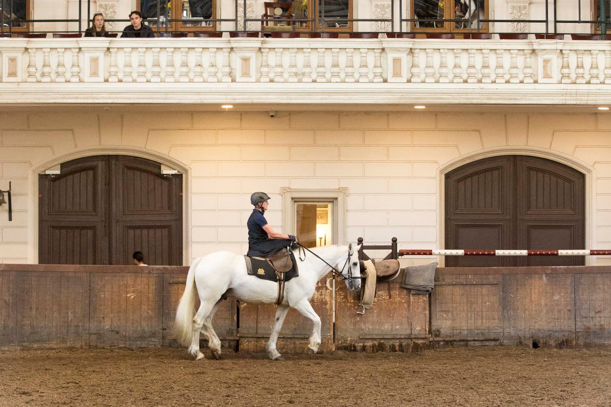 zoë zit naast de pony en kijkt deze aan terwijl de pony zich laat aanhalen