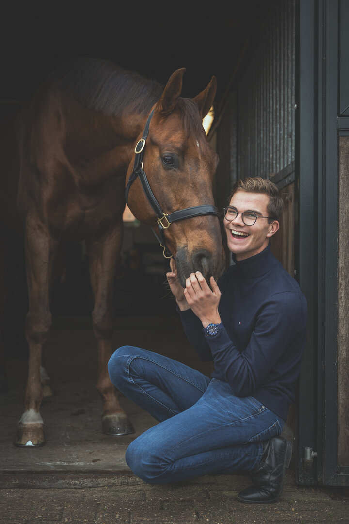 Marten Luiten zit gehurkt naast zijn paard Johnny