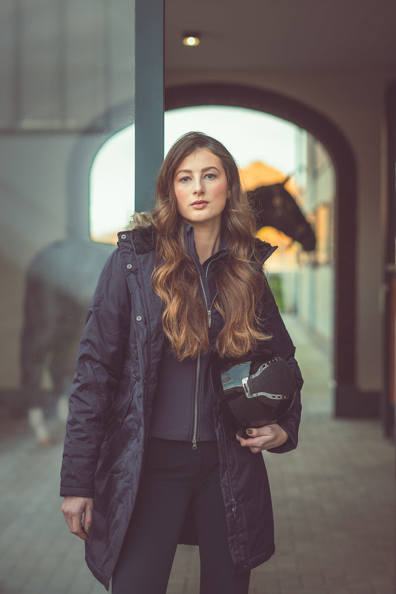 dressuuramazone milou laat kleding van horka zien en heeft de nieuwste veiligheidshelm in haar hand