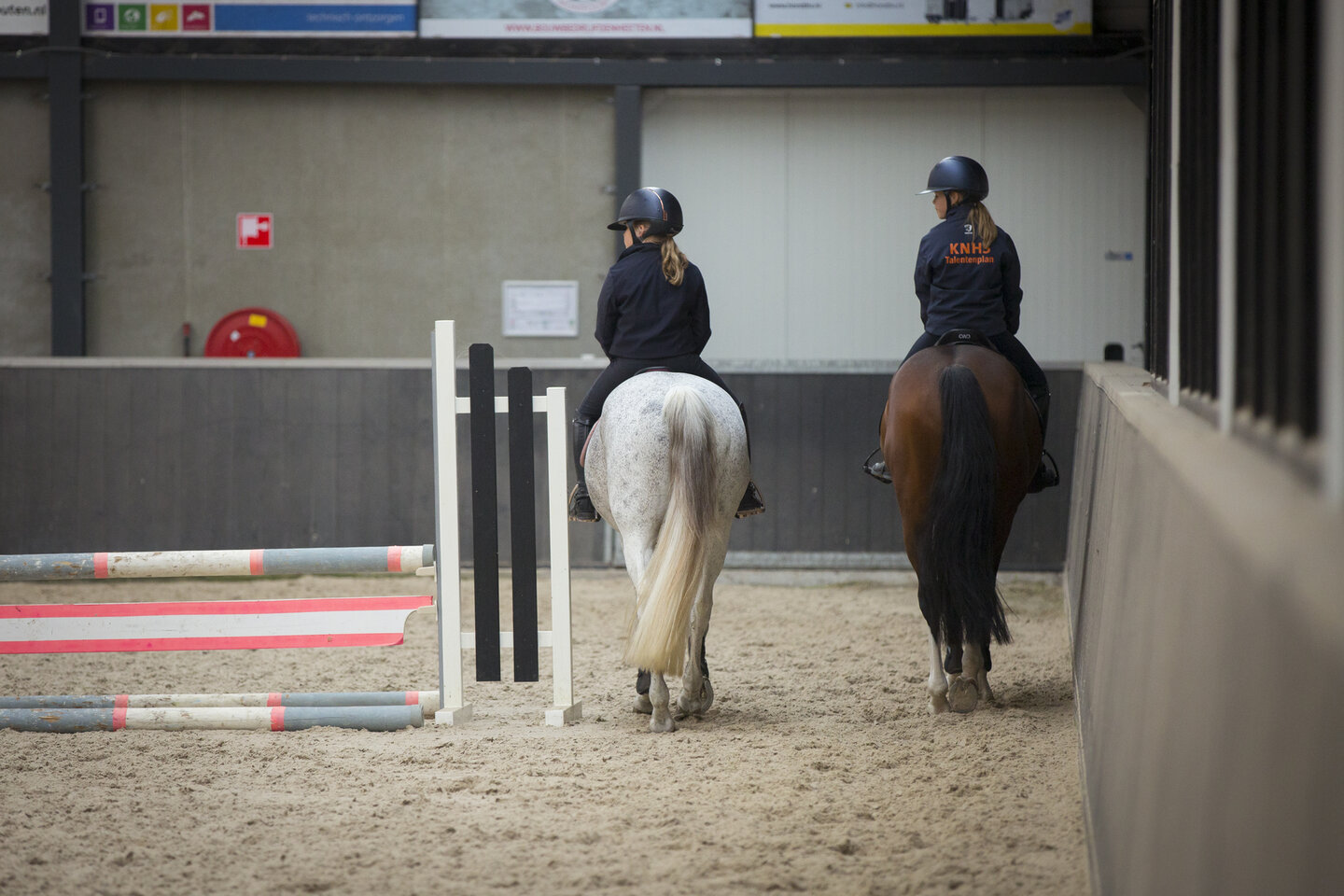 ponyruiters stappen in de binnenbak met KNHS-jas