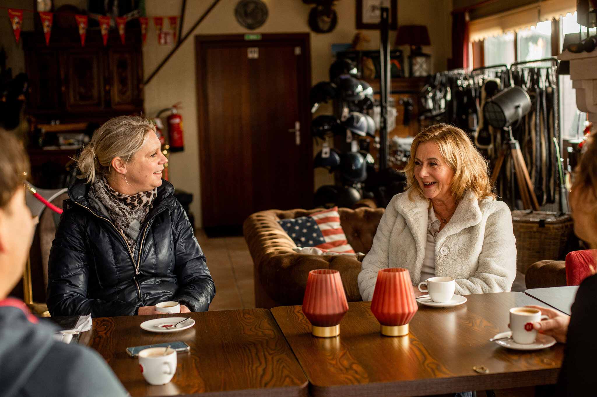 irene lacht en anja luistert aandachtig terwijl ze aan tafel zitten