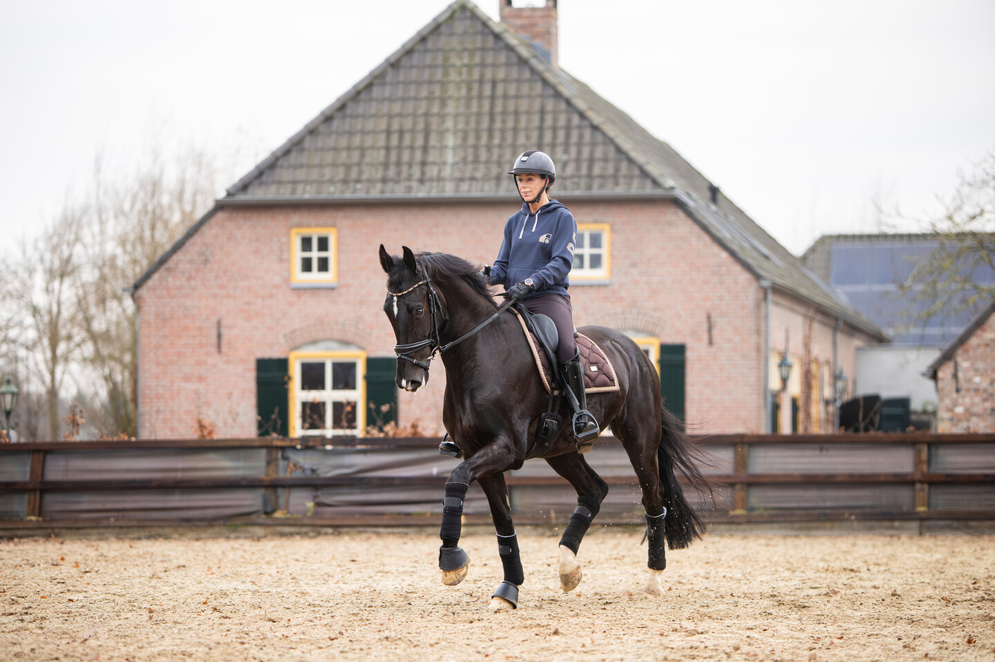 manegehouder sandra melten loopt naast een aantal ruiters met hun paard